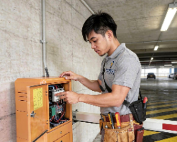 Technician inspecting and repairing automated barrier and gate systems